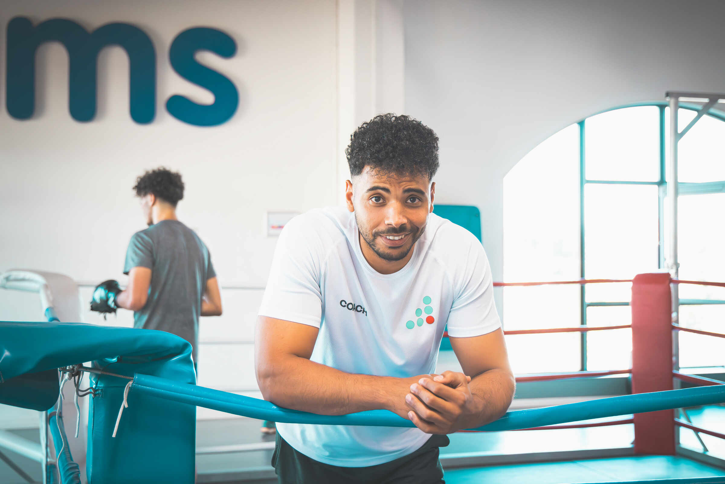 Coach souriant sur le ring de boxe dans le club Jims